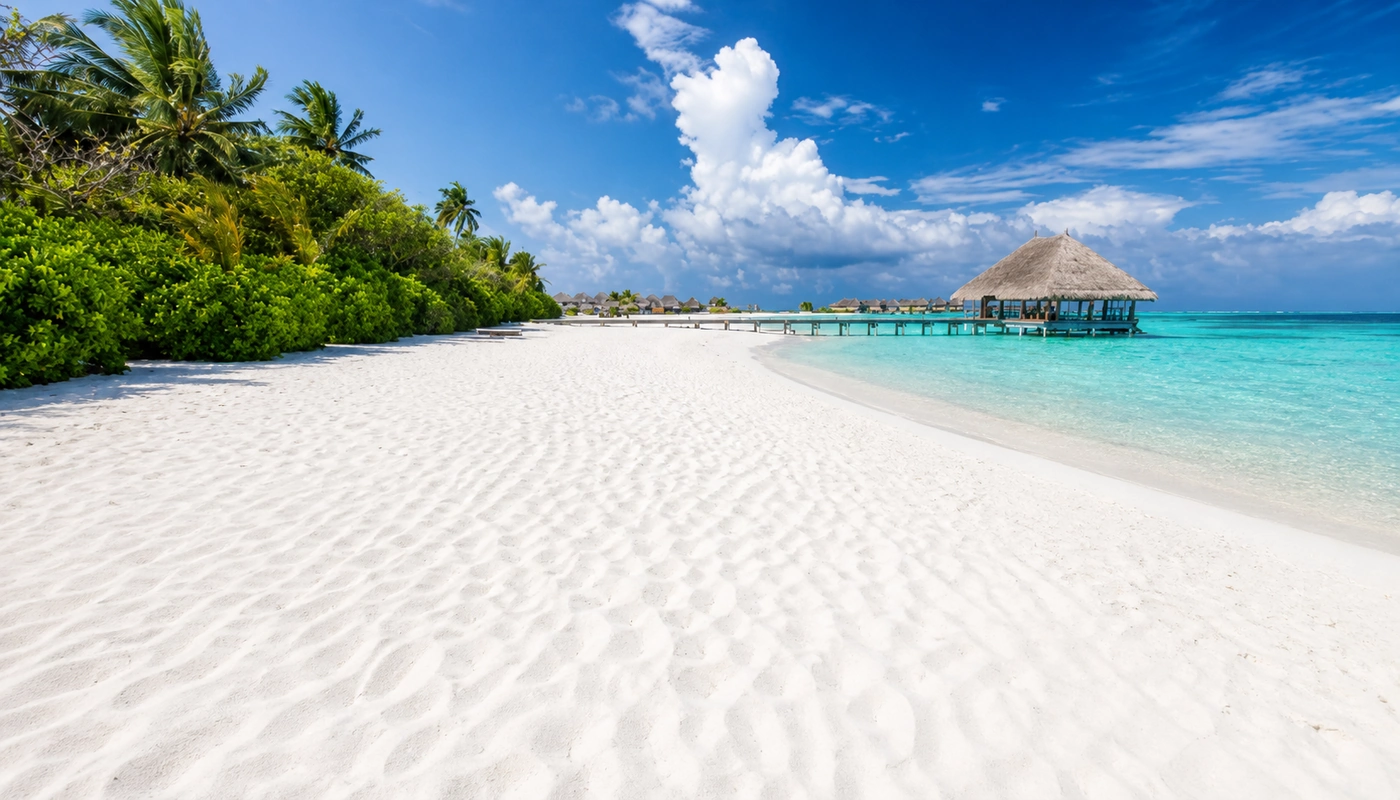 White sand beach with a thatched jetty pavilion over the lagoon