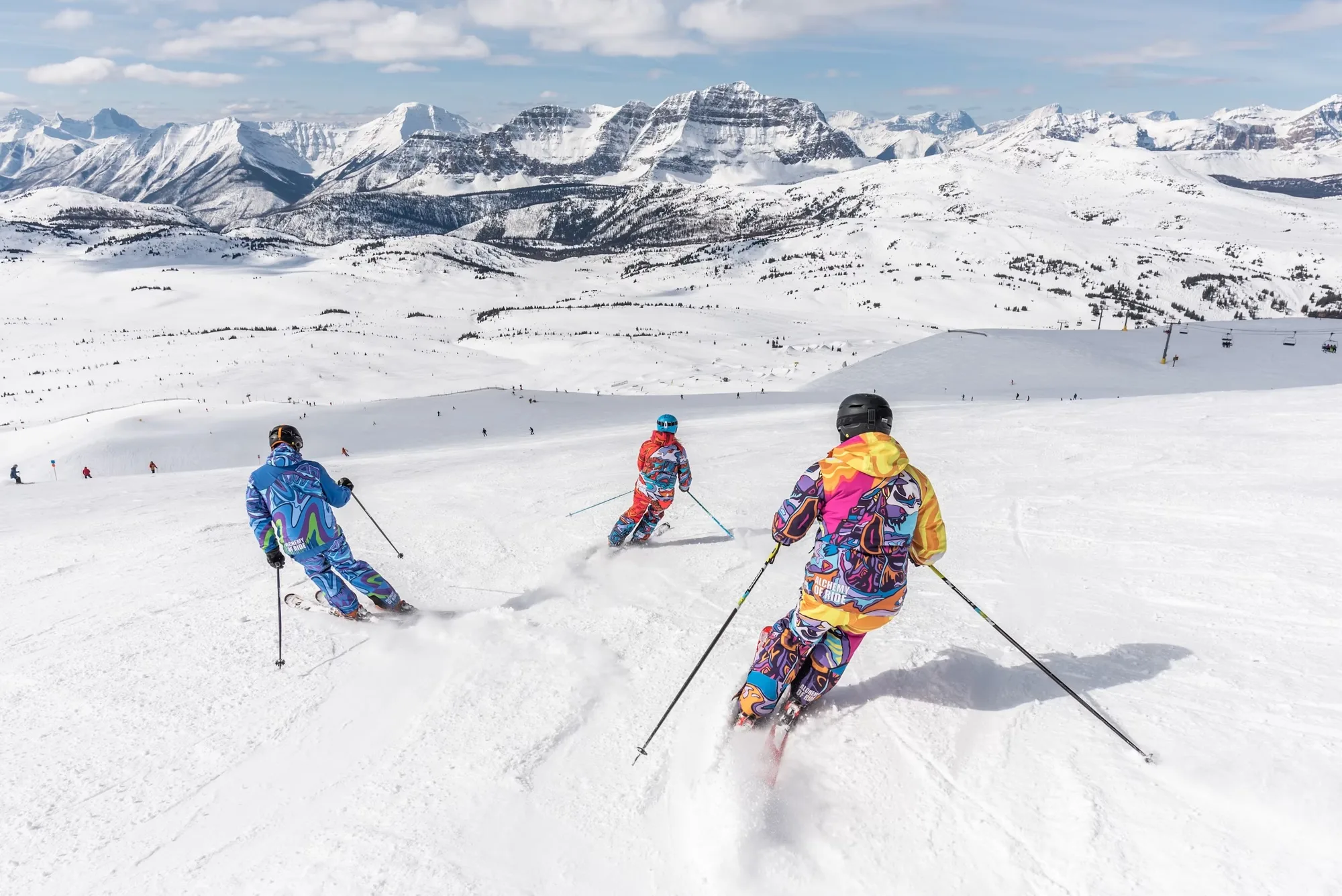 Skiers on an alpine piste with mountain views